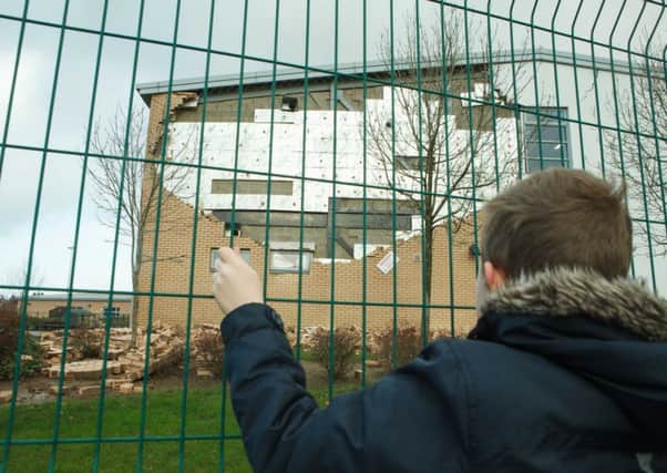 A boy stands outside Oxgangs Primary School, where Storm Gertrude brought down a wall. Picture: Toby Williams