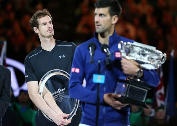 Australian Open champion Novak Djokovic of Serbia holds the Norman Brookes Challenge Cup as Andy Murray looks on. Picture: Getty Images