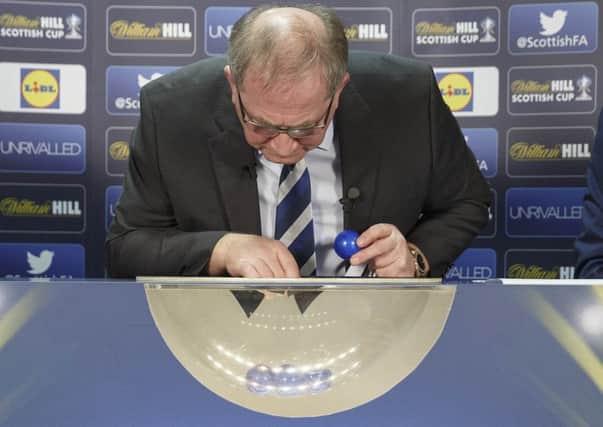 Scottish FA president Alan McRae looks for the balls after the first draw was aborted