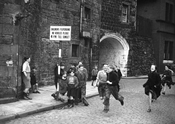 children run on Johnston Street in Leith in 1952. The sign shows the street was a designated childrens playground, with vehicles banned after 4pm.
