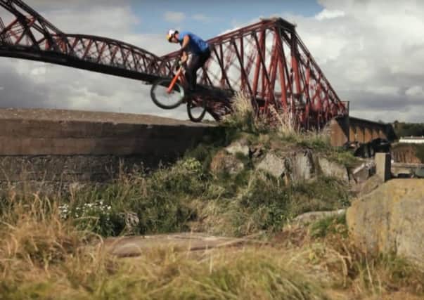 Danny MacAskill on Inchgarvie with the Forth Bridge behind him from the video Way Back Home