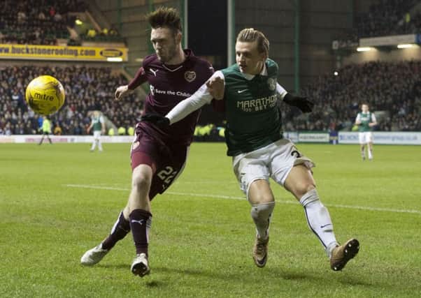 Jordan McGhee holds off Jason Cummings while playing centre back at Easter Road