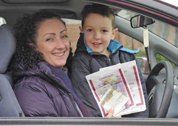 Mairi Holden and son Oscar with the cash left on her windscreen. Picture: Neil Hanna