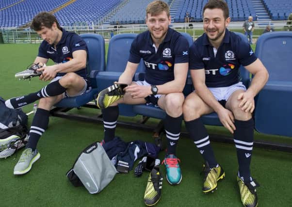Greig Laidlaw, right, puts on his boots before kicking practice in the 
Stadio Olimpico with Peter Horne, left, and Finn Russell. Picture: Ian Rutherford