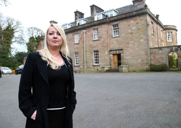 Councillor Kelly Parry pictured at the former children's care home, however, the building set to become an HMO is situated behind the building pictured