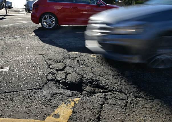 Drivers negotiate potholes in Captain's Road. Picture: John Savage