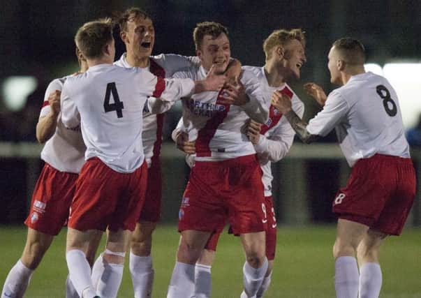 Keith Murray, centre, is mobbed by his team-mates after his superb strike clinched victory. Pic: Toby Williams