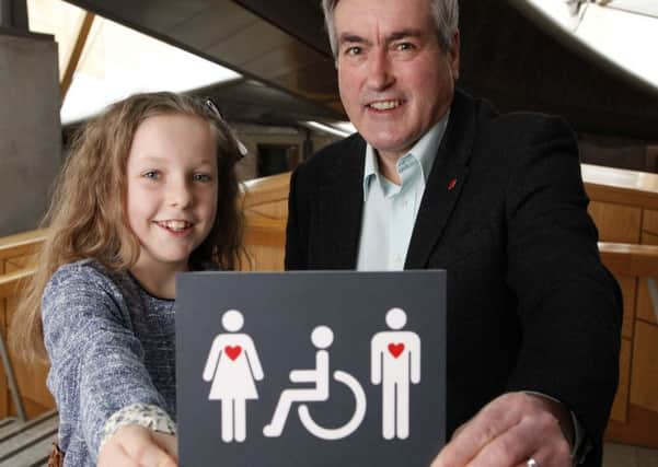Iain Gray MSP and ten-year-old Grace Warnock unveil a new disabled toilet sign, designed by Grace, which is now in place at the Scottish Parliaments accessible toilets.  Picture: Andrew Cowan/Scottish Parliament