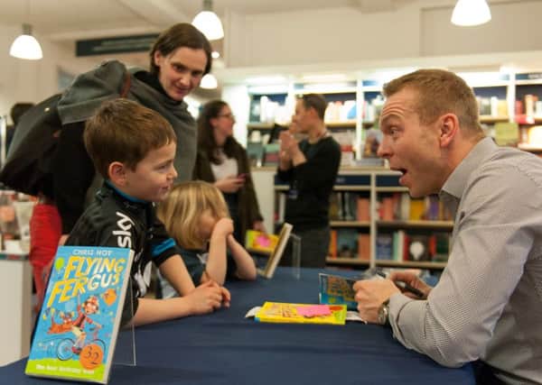 Sir Chris Hoy signs copies of his book for six-year-old Hamish Mayes. Picture: Andrew O'Brien