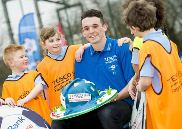 John McGinn with pupils who brought a cake from Tescos to celebrate his first call-up to Scotlands senior team.