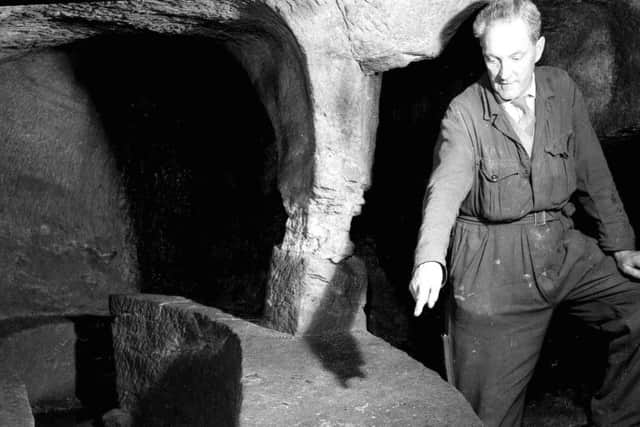 David Watt points to a recepticle for a punch bowl in Gilmerton Cove.