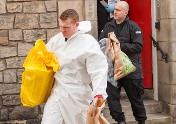 Police and forensic officers remove items from the flat. Picture: Toby Williams
