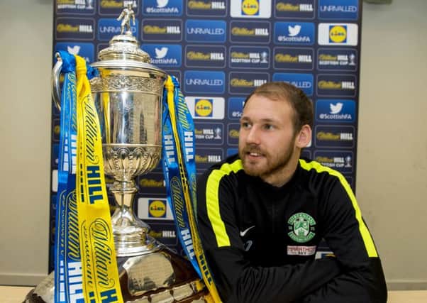 Martin Boyle gets a close look at the Scottish Cup. Pic: SNS