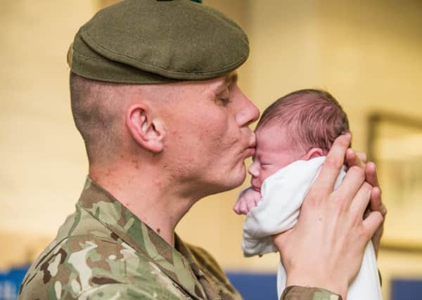 Private Christopher Edgar meets his two-week-old baby Caleb for the first time. Picture: Ian Georgeson