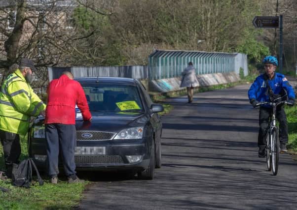 A passing cyclist looks askance at the surveyors with their parked car. Picture: Scott Taylor