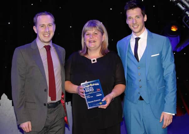 Sharon Duncan receives the carer award presented by kevin Crawford  at the local hero awards 2015. Also pictured is  compere Scott Hoatson, right. Picture: Scott Louden