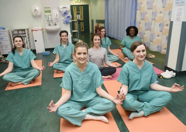 Staff Nurses from theatre recovery Jane Waldron, front left, and Catriona Byrne, front right, join in a yoga class for staff run by Mary Ramage to help with empathy. Picture: Greg Macvean