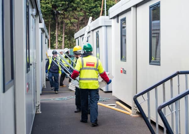 Workers install a temporary classroom. Picture: Ian Georgeson