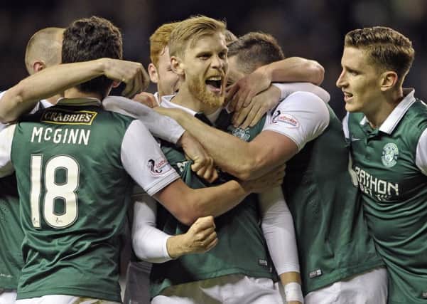 The Hibs players mob defender Niklas Gunnarsson after his excellent strike had put the home side 3-1 up against Rangers. Pic: Neil Hanna