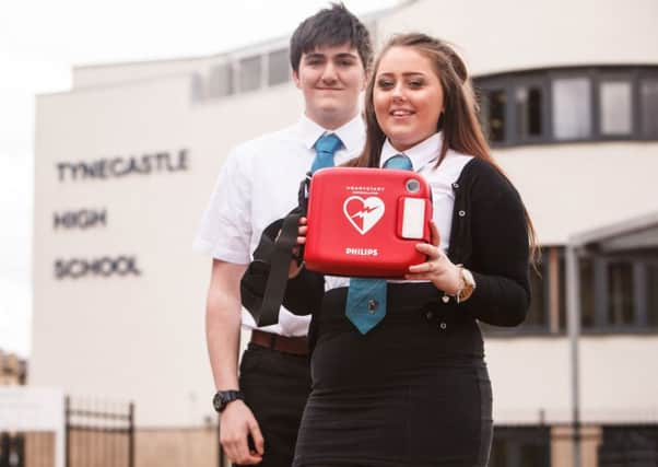 Pupils Rebecca Howard and James Gibson with Tynecastle High's defibrillator. Picture: Toby Williams