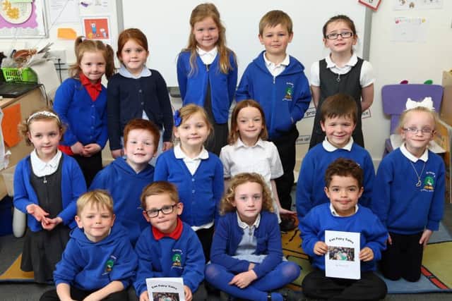 Pupils from P1c class at Burnbrae Primary School with the book of fairytales they put together