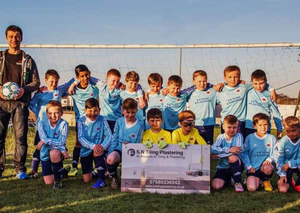 Loanhead Miners Youth football team proudly model new kit provided by their sponsor, Slawomir Nowosadzki, of SN Tiling and Plasterin