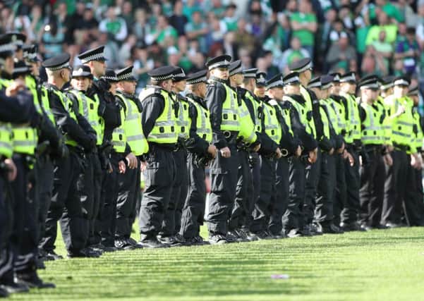 Police form a cordon as Hibs fans invade the pitch at the final whistle after winning the Scottish Cup final. Picture: Getty