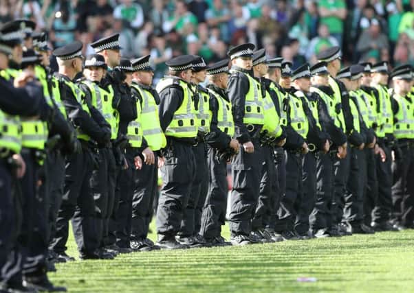 Police form a cordon as Hibs fans invade the pitch at the final whistle after winning the Scottish Cup Final. Picture: Getty