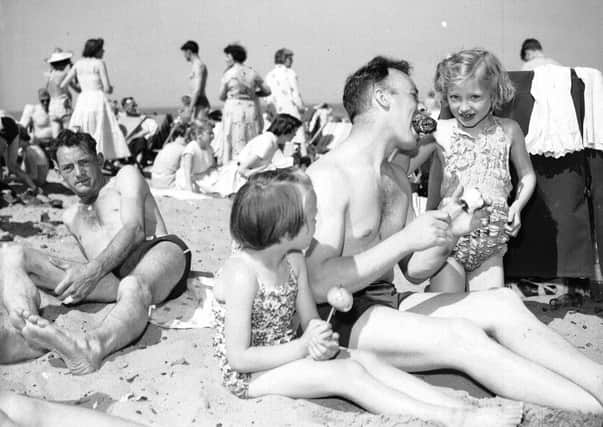 Holidaymakers at Portobello beach in July 1958. Mr W Devon and Caroline Devon and Linda Gillespie enjoying toffee apples.