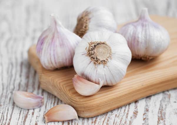 Garlic bulbs on a wooden board. Photo: PA Photo/thinkstockphotos