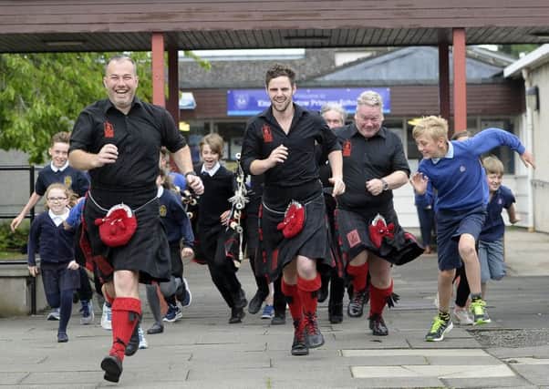 The Red Hot Chilli Pipers and pupils from King's Meadow Primary School rehearse for the music video. Picture: Neil Hanna