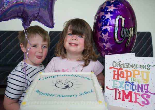 Murray Robertson (4) and Sophie Allan (3) admire the cake marking the excellent inspection report