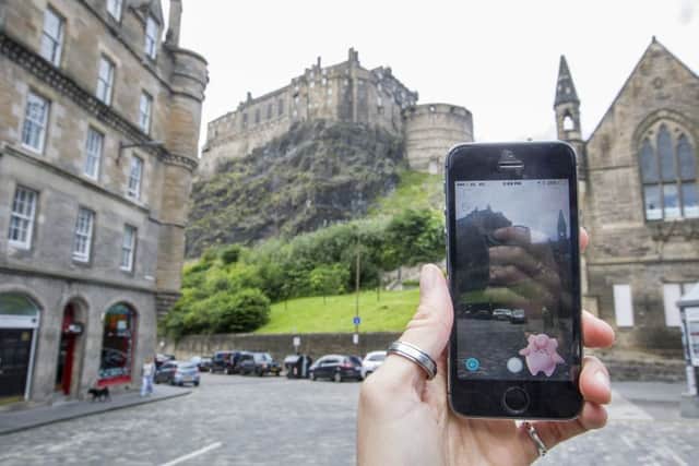Pokemon Go in Edinburgh's Grassmarket looking up at the Castle. Picture: SWNS