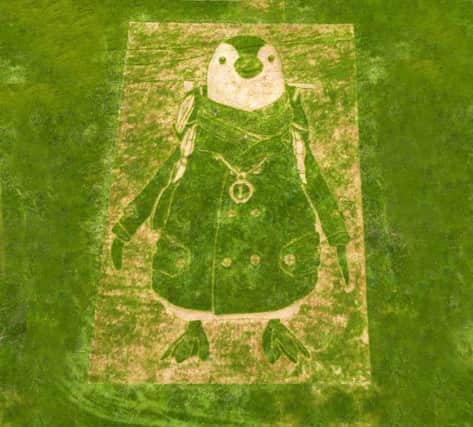 Lawn artist Chris Naylor creates "Wilbur" the Scottish Gas mascot into the side of The Pentland Hills in Edinburgh. Picture; Roddy Scott