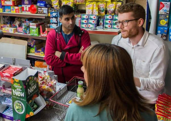 Zubair Akram takes direction from director Sean Dunn  (right) at the Ali Brothers shop in Loanhead. With Game of Thrones actress Kate Dickie in the foreground (back to camera)