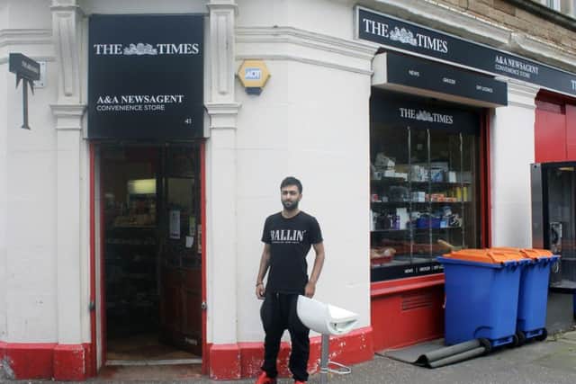 Zee Ahmed next to a blood stained stool his father Tahir Ahmed, 54, was sitting on when he was attacked by a machete wielding assailant . Picture: PA