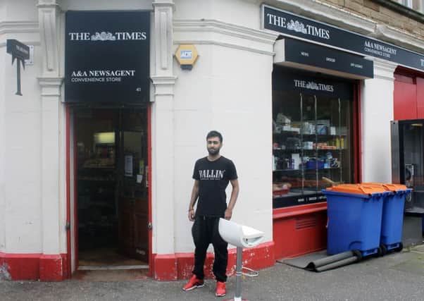 Zee Ahmed next to a blood stained stool his father Tahir Ahmed, 54, was sitting on when he was attacked by a machete wielding assailant . Picture: PA