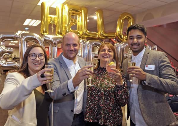 Manager Neil Millington, second left, toasts the store's opening with some members of his team. Picture:
 Neil Hanna