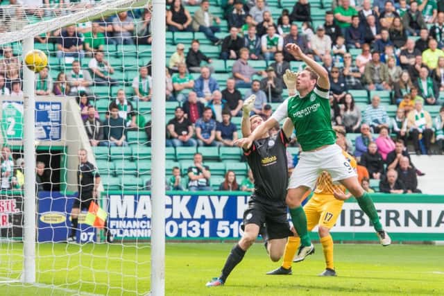 Grant Holt out-jumps Derek Gaston to net his first goal for Hibs. Pic: Ian Georgeson