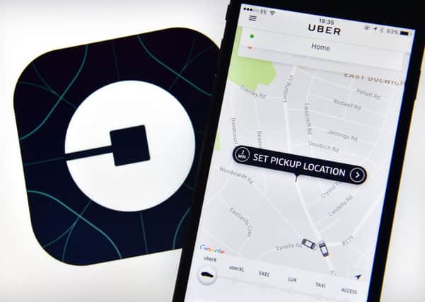 The Uber home page is displayed on an iPhone next to the company logo on a computer screen on August 3, 2016 in London, England.  Picture; Getty