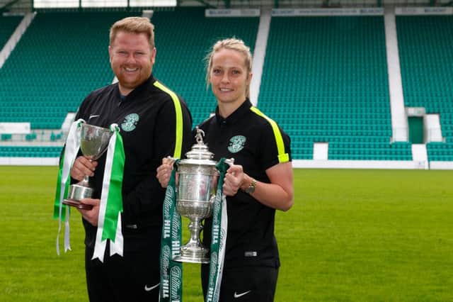 Hibs coach Chris Roberts with Hibs Ladies centre half Joelle Murray holding the Ladies League cup and the Scottish Cup respectively