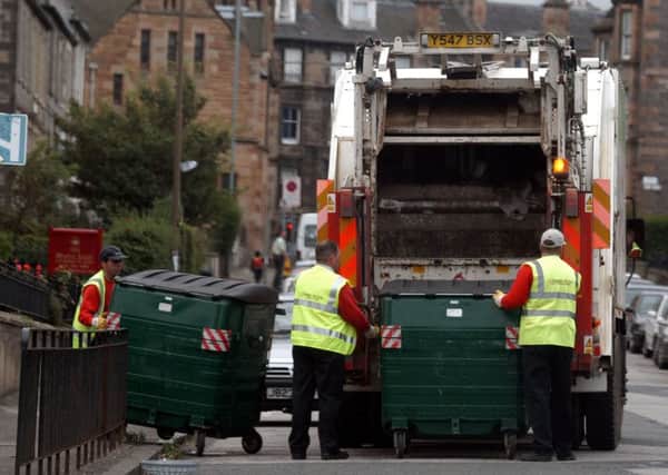 Binmen emptying wheelie bin into Rubbish Lorry in Edinburgh street
