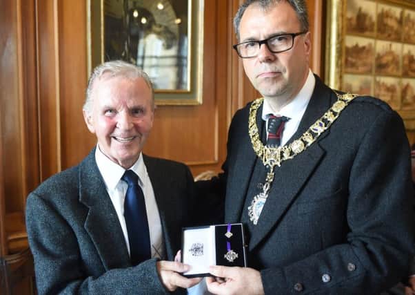 Lord Lieutenant Donald Wilson presents Roy Clark with an Elizabeth Cross on behalf of his brother. Picture: PA
