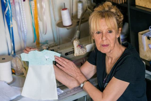 Margaret Halliday with one of the baby funeral gowns she makes for grieving parents. Picture: Ian Georgeson