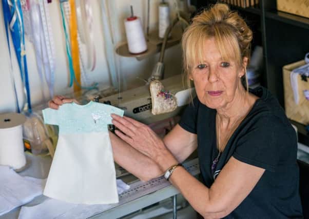 Margaret Halliday with one of the baby funeral gowns she makes for grieving parents. Picture: Ian Georgeson