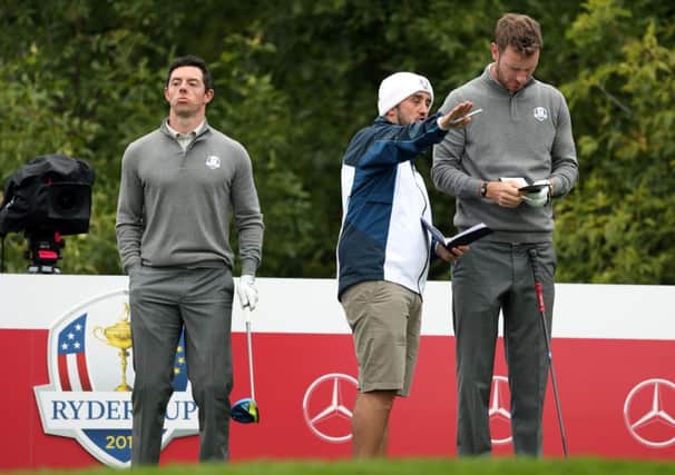 Mark Crane offers Chris Wood some advice during a practice round at Hazeltine today with Rory McIlroy. Picture: Getty Images