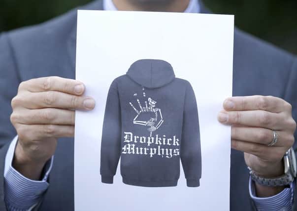 Detective Inspector Donnie MacLeod from the Public Protection Unit at Police Scotland holds a picture of a hooded top that it is believed the suspect was wearing. Picture PA