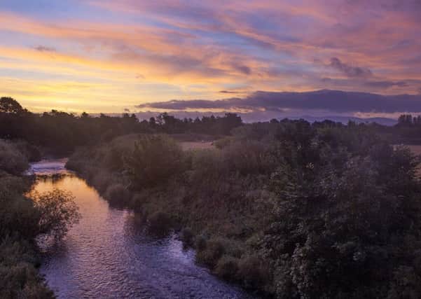 A colour full sky as the sunrises over the River Almond in West Lothian on an autumnal morning. Picture: SWNS