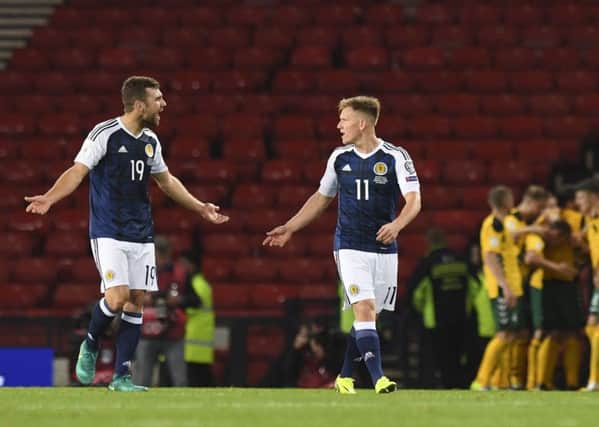 James McArthur, left, and Matt Ritchie start the inquest as Lithuania celebrate their opener at Hampden. Pic: SNS
