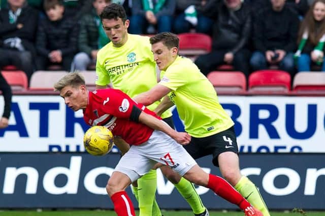 Hibs defender Paul Hanlon and Dunfermline's on-loan Hearts striker Gavin Reilly tussle for the ball watched by John McGinn